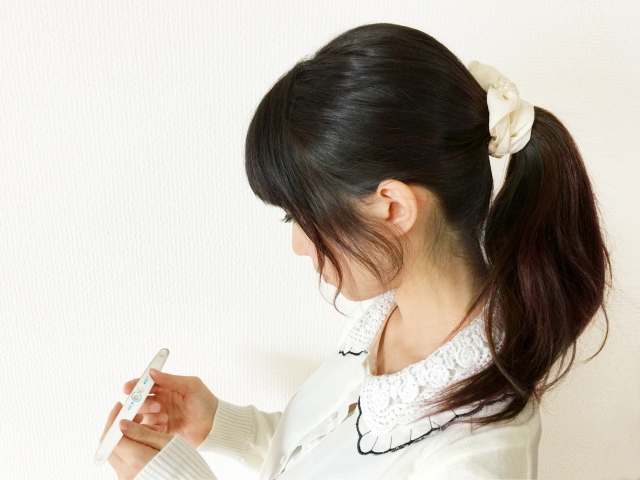 妊娠検査キットを見る女性